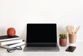 Office desk table with supplies. Top view. Copy space for text. Laptop, pensils, smartphon, apple, glass and flower.