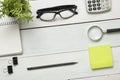 Office desk table with supplies. Top view. Copy space for text. Notepad, pen, glasses, calculator, reminder, flower. Royalty Free Stock Photo