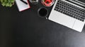 Office desk top view black leather table with laptop computer, cup of coffee and office supplies Royalty Free Stock Photo