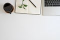 Office desk top view table with laptop, coffee, plant, notebook and pencil