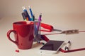 Office desk with various items including coffee cup and smart phone over blur background