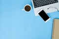 Flat lay top view mockup photo of working space with laptop, smartphone, coffee and stationary on blue pastel background. Royalty Free Stock Photo