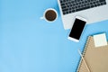 Flat lay top view mockup photo of working space with laptop, smartphone, coffee and stationary on blue pastel background. Royalty Free Stock Photo