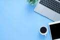 Flat lay top view mockup photo of working space with laptop, smartphone, coffee up and notebook on blue pastel background. Royalty Free Stock Photo