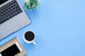 Flat lay top view mockup photo of working space with laptop, smartphone, coffee up and notebook on blue pastel background. Royalty Free Stock Photo