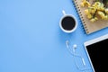 Flat lay top view mockup photo of working space with smart device, coffee cup and notebook on blue pastel background. Royalty Free Stock Photo