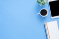 Office desk working space - Flat lay top view mockup photo of working space with tablet, coffee cup and notebook on blue pastel Royalty Free Stock Photo