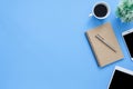 Flat lay top view mockup photo of working space with tablet, phone, coffee cup and notebook on blue pastel background. Royalty Free Stock Photo