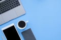 Flat lay top view mockup photo of working space with laptop, smartphone, coffee up and notebook on blue pastel background. Royalty Free Stock Photo