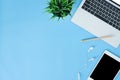 Flat lay top view mockup photo of working space with laptop, tablet and notebook placing on blue pastel background. Royalty Free Stock Photo