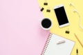 Flat lay top view of working space with white blank notebook, earphone, coffee cup and mock up phone on pastel. Royalty Free Stock Photo