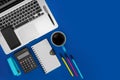 Office desk working space. Laptop, notebook, calculator and coffee on blue background. Business concept Royalty Free Stock Photo