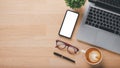 Office desk workplace with blank screen smartphone, laptop, eyeglass, pen and cup of coffee Royalty Free Stock Photo