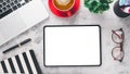 Office desk workplace with blank screen tablet, laptop, pen, eyeglass, notebook and cup of coffee. Royalty Free Stock Photo