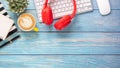 Office desk workplace with keyboard, mouse, headphone, pen, notebook and cup of coffee Royalty Free Stock Photo