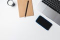 Office desk. Workplace with a modern laptop, candle, paper cup of coffee, notebook, pencil, smartphone Royalty Free Stock Photo