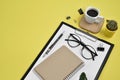 Office desk workspace with blank clip board, office supplies, pen, cactus, green leaf, coffee cup on a wooden stand and eye Royalty Free Stock Photo