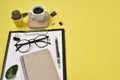 Office desk workspace with blank clip board, office supplies, pen, cactus, green leaf, coffee cup on a wooden stand and eye Royalty Free Stock Photo