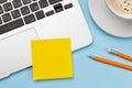 Office desk with yellow sticker, coffee and laptop Royalty Free Stock Photo
