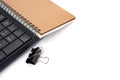 Office desktop with group of Black metal binder paper clip clamps, keyboard and note book isolated on white - image Royalty Free Stock Photo