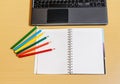 Office desktop with laptop, opened notebook and pencils Royalty Free Stock Photo