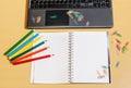 Office desktop with laptop, opened notebook and pencils Royalty Free Stock Photo