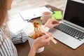 Office employee using laptop while having noodles for lunch at workplace, closeup Royalty Free Stock Photo