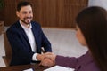 Office employees shaking hands over table with documents Royalty Free Stock Photo