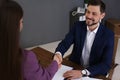 Office employees shaking hands over table with documents Royalty Free Stock Photo