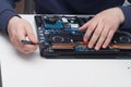 An office equipment repairman disassembles a laptop to find a fault Royalty Free Stock Photo