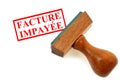 Rubber stamp showing in french unpaid invoice close up on white background