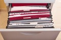 Office filing cabinet full of folders with documents organized by dividers