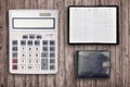 Office flat lay composition with calculator, address book and black purse on brown wooden table background with top view. Royalty Free Stock Photo