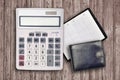 Office flat lay composition with calculator, address book and black purse on brown wooden table background with top view. Royalty Free Stock Photo