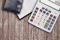 Office flat lay composition with calculator, address book and black purse on brown wooden table background with top view. Royalty Free Stock Photo