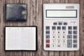 Office flat lay composition with calculator, address book and black purse on brown wooden table background with top view. Royalty Free Stock Photo