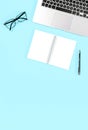 Office flat lay template. Laptop notebook pen blue background Royalty Free Stock Photo