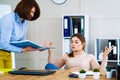 Office girl ignoring angry boss and meditating at workplace Royalty Free Stock Photo