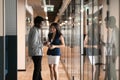 In office hallway diverse colleagues having friendly conversation