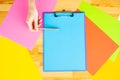 Office Hand Holding a Folder with a Blue Color Paper and Pen on the Colored Background of the Wooden Table. Copyspace. Place for T Royalty Free Stock Photo