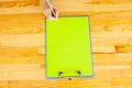 Office Hand Holding a Folder with a Green Color Paper and Pen on the Background of the Wooden Table. Copyspace. Place for Text. Royalty Free Stock Photo
