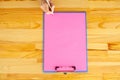 Office Hand Holding a Folder with a Pink Color Paper and Pen on the Background of the Wooden Table. Copyspace. Place for Text. Royalty Free Stock Photo