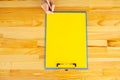 Office Hand Holding a Folder with a Yellow Color Paper and Pen on the Background of the Wooden Table. Copyspace. Place for Text. Royalty Free Stock Photo