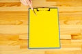 Office Hand Holding a Folder with a Yellow Color Paper and Pen on the Background of the Wooden Table. Copyspace. Place for Text. Royalty Free Stock Photo