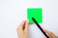 Office Hand Holding a Green Color Sticker and Pen on White Background. Copyspace. Place for Text. Royalty Free Stock Photo