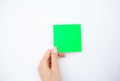 Office Hand Holding a Green Color Sticker on White Background. Copyspace. Place for Text. Royalty Free Stock Photo