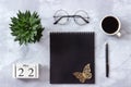 Office or home table desk. Wooden cubes calendar May 22. Black notepad, cup of coffee, succulent, glasses on marble background Royalty Free Stock Photo