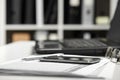 Office interior closeup. Table with laptop, documents, smartphone and eyeglasses