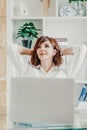 Office laptop woman. Calm smiling businesswoman relaxing on comfortable office chair hands behind head, happy woman Royalty Free Stock Photo