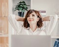 Office laptop woman. Calm smiling businesswoman relaxing on comfortable office chair hands behind head, happy woman Royalty Free Stock Photo